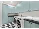 Well-organized laundry room with a modern washer and dryer, ample storage, and stylish checkerboard flooring at 9820 N 87Th Pl, Scottsdale, AZ 85258
