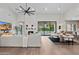 A modern living room and dining area with neutral tones, a fireplace, and sliding glass doors to the backyard at 9820 N 87Th Pl, Scottsdale, AZ 85258