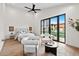 This primary bedroom has floor to ceiling windows, hardwood floors, ceiling fan, and a seating area at 9820 N 87Th Pl, Scottsdale, AZ 85258
