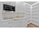 Bright pantry with white cabinets, marble counter, and open shelving at 9820 N 87Th Pl, Scottsdale, AZ 85258