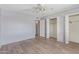 Bright bedroom features wood floors, ceiling fan and double closets with white doors at 10236 N 105Th Dr, Sun City, AZ 85351