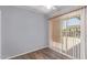 Bedroom showcasing hardwood flooring and a sliding glass door for natural light and outdoor access at 10236 N 105Th Dr, Sun City, AZ 85351
