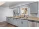 Updated kitchen featuring granite countertops, gray cabinetry, stainless steel appliances, and modern fixtures at 10236 N 105Th Dr, Sun City, AZ 85351