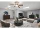 Bright living room featuring hardwood floors, ceiling fan, area rug, and modern decor at 10236 N 105Th Dr, Sun City, AZ 85351