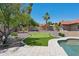 Lush backyard featuring a putting green, palm trees, and access to the swimming pool at 10450 E Terra Dr, Scottsdale, AZ 85258