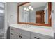 Bathroom vanity with white counters and cabinets, silver hardware, and an oversized beveled mirror at 10450 E Terra Dr, Scottsdale, AZ 85258