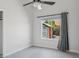 Bright, airy bedroom featuring a ceiling fan and a large window with backyard views at 10450 E Terra Dr, Scottsdale, AZ 85258