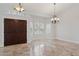 Bright entryway featuring travertine floors, double doors, plantation shutters, and decorative light fixtures at 10450 E Terra Dr, Scottsdale, AZ 85258