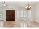 Bright entryway featuring travertine floors, double doors, plantation shutters, and decorative light fixtures at 10450 E Terra Dr, Scottsdale, AZ 85258
