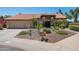 Charming single-story home featuring well-manicured desert landscaping, a red tile roof, and a two-car garage at 10450 E Terra Dr, Scottsdale, AZ 85258