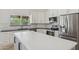 Well-lit kitchen showcasing white cabinets, stainless steel appliances, and a large island with stone countertops at 10450 E Terra Dr, Scottsdale, AZ 85258