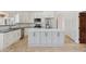 A modern kitchen features a large central island, white cabinets, stainless appliances, and tiled flooring at 10450 E Terra Dr, Scottsdale, AZ 85258