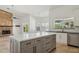Bright kitchen featuring a central island, stone fireplace, white cabinetry, and stainless steel appliances at 10450 E Terra Dr, Scottsdale, AZ 85258
