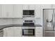 Well-appointed kitchen featuring stainless steel appliances, stone countertops, and bright white cabinets at 10450 E Terra Dr, Scottsdale, AZ 85258