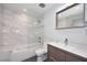 Bathroom with updated fixtures, marble tiling, a soaking tub and a frameless glass shower screen at 11007 N 26Th St, Phoenix, AZ 85028