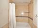 Tiled shower and bathtub with a shower curtain, featuring neutral tile and a decorative accent row at 11007 N 26Th St, Phoenix, AZ 85028