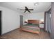 Bedroom with wood bed frame, gray bedding, tile flooring, and gray accent wall at 11007 N 26Th St, Phoenix, AZ 85028