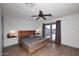 Bedroom with wood bed frame, gray bedding, ceiling fan, tile flooring, and access to backyard at 11007 N 26Th St, Phoenix, AZ 85028