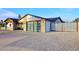 Modern home with a glass garage door, brick accents, metal gate, and expansive paved driveway at 11007 N 26Th St, Phoenix, AZ 85028