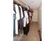 Walk-in closet featuring hanging clothes on racks, tile flooring, and additional storage space at 11007 N 26Th St, Phoenix, AZ 85028