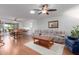 Bright living room featuring laminate flooring, ceiling fan, skylight, and access to dining and kitchen areas at 12711 W Omega Dr, Sun City West, AZ 85375