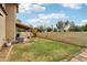 A spacious backyard featuring lush grass, a covered patio, and a well-maintained block wall at 1344 N Brittany Ln, Gilbert, AZ 85233