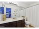 Bathroom with dark wood cabinets, a long countertop, and a full-size mirror at 1344 N Brittany Ln, Gilbert, AZ 85233