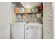 Functional laundry room with washer, dryer, and ample shelving for storage at 1344 N Brittany Ln, Gilbert, AZ 85233
