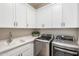 Bright laundry room with white cabinets, quartz countertops, stainless steel washer and dryer at 14507 N Valencia Dr, Fountain Hills, AZ 85268