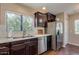Charming kitchen featuring dark cabinets, stainless steel appliances, and ample natural light from the window at 15252 N 100Th St # 2157, Scottsdale, AZ 85260
