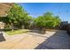 Landscaped backyard with mature trees providing shade over a brick patio at 1541 E Cinnabar Ave, Phoenix, AZ 85020