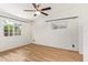 Bedroom featuring painted brick walls, wood floors, ceiling fan and bright windows at 1541 E Cinnabar Ave, Phoenix, AZ 85020