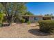 Inviting single-story home with a well-maintained desert landscape, mature trees, and a charming arched entryway at 1541 E Cinnabar Ave, Phoenix, AZ 85020