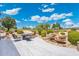 Charming backyard featuring a rock waterfall, a patio with tile flooring, golf course views, and desert landscaping at 15502 W Agua Linda Ln, Surprise, AZ 85374