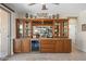 Elegant custom bar area with built-in cabinets, a wine rack, a mini-fridge, and decor at 15502 W Agua Linda Ln, Surprise, AZ 85374
