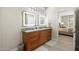 Bathroom with double sinks, granite countertop, and illuminated mirrors at 15502 W Agua Linda Ln, Surprise, AZ 85374