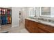 Bathroom with double sinks, granite countertop, and illuminated mirrors at 15502 W Agua Linda Ln, Surprise, AZ 85374