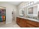 Bathroom with double sinks, granite countertop, and illuminated mirrors at 15502 W Agua Linda Ln, Surprise, AZ 85374