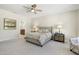 Spacious primary bedroom featuring a ceiling fan, ensuite bath and plush carpet at 15502 W Agua Linda Ln, Surprise, AZ 85374