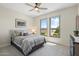 Cozy bedroom with plush carpet, two windows, and a comfortable bed with decorative pillows at 15502 W Agua Linda Ln, Surprise, AZ 85374