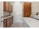 Laundry room with full-size washer and dryer and custom cabinets at 15502 W Agua Linda Ln, Surprise, AZ 85374