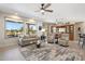 Bright living room featuring large windows with desert views, a custom bar, and neutral decor at 15502 W Agua Linda Ln, Surprise, AZ 85374