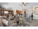 Open-concept living area featuring hardwood floors, multiple ceiling fans, a wet bar, and seamless flow into the kitchen at 15502 W Agua Linda Ln, Surprise, AZ 85374