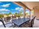 Covered patio with an outdoor dining area, comfortable seating, and scenic backyard views at 15502 W Agua Linda Ln, Surprise, AZ 85374