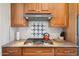 Close-up of a modern stovetop with granite countertop and decorative tile backsplash at 15502 W Agua Linda Ln, Surprise, AZ 85374