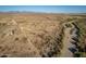 Desert landscape, a single story home, a creek bed, and mountains in the background at 15612 S Tuthill Rd, Buckeye, AZ 85326