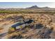 A desert home surrounded by desert vegetation, dirt roads, and a view of the mountains at 15612 S Tuthill Rd, Buckeye, AZ 85326