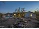 Single-story home with lawn, desert landscape, and mountain views at dusk at 15612 S Tuthill Rd, Buckeye, AZ 85326