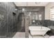 Elegant bathroom showcasing a walk-in shower with black marble tile and a freestanding tub at 15612 S Tuthill Rd, Buckeye, AZ 85326