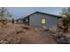 Single-story home with xeriscaped yard featuring rocks and native desert vegetation at 15612 S Tuthill Rd, Buckeye, AZ 85326